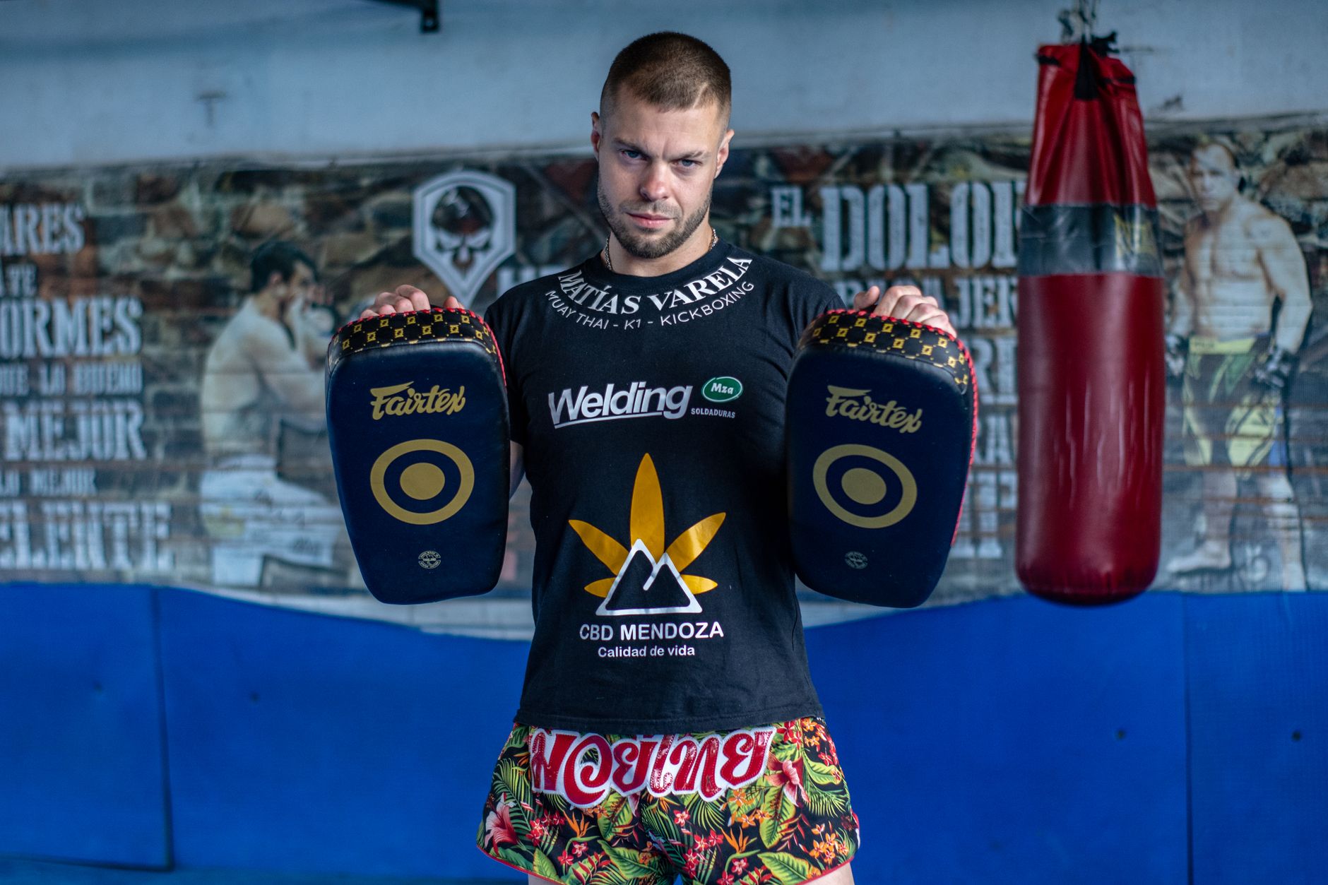 Entrenamiento de Muay Thai con pads y protecciones en gimnasio